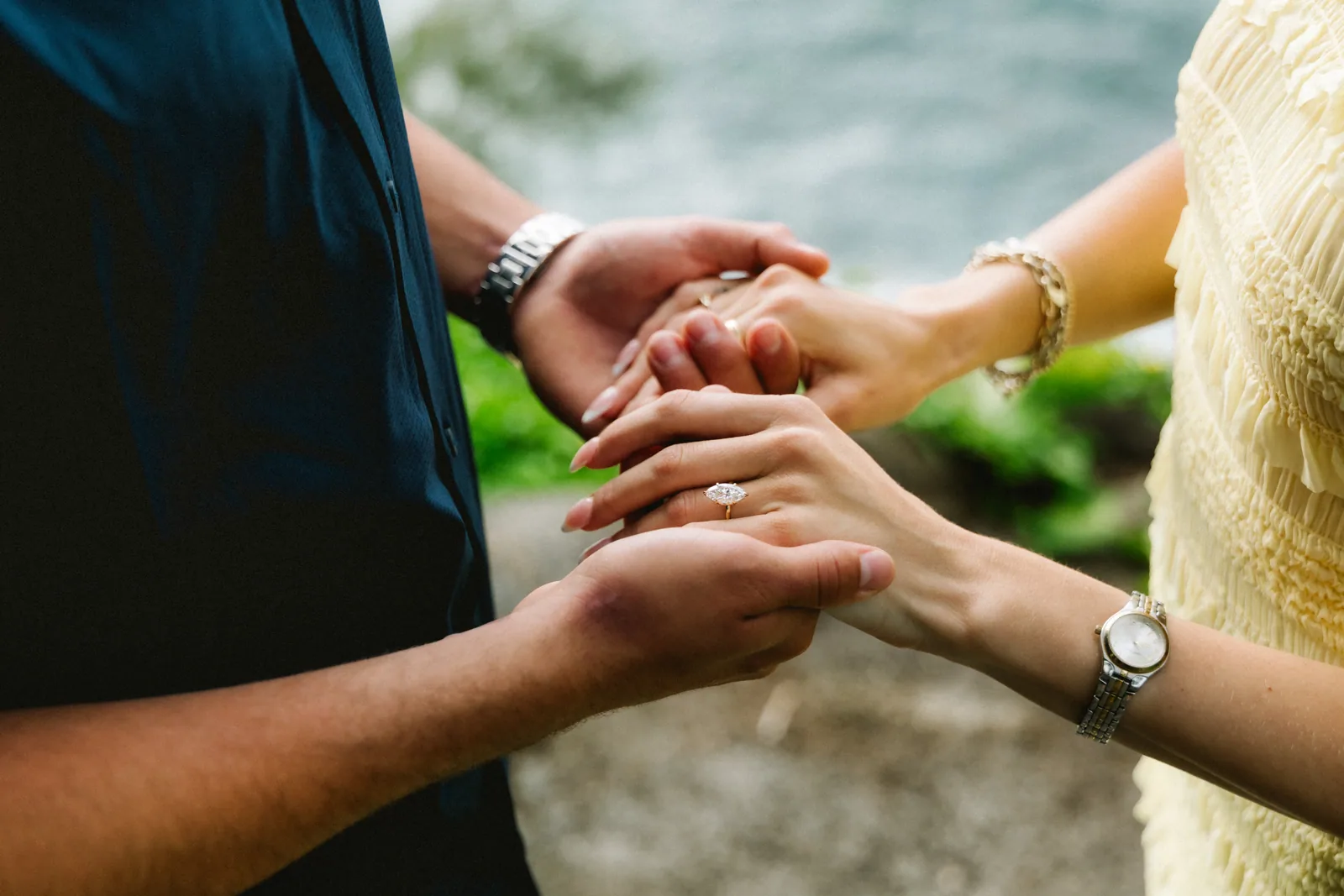 Both sets of hands clasped together, the new ring visible between them